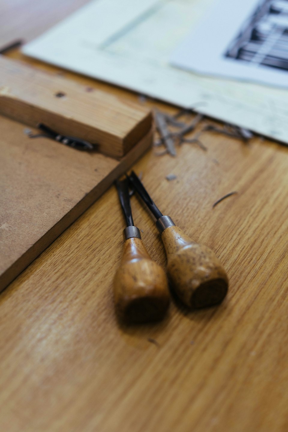 Due scalpelli da legno riposano su un banco da lavoro coperto di trucioli.